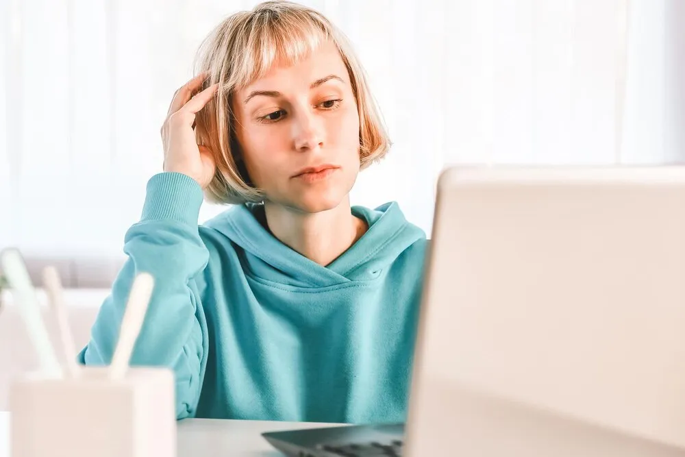 bizneswoman słuchająca wykładu edukacyjnego na komputerze oglądająca webinar ucząca się na kursach online robiąca notatki w papierowym zeszycie koncepcja e-learningu