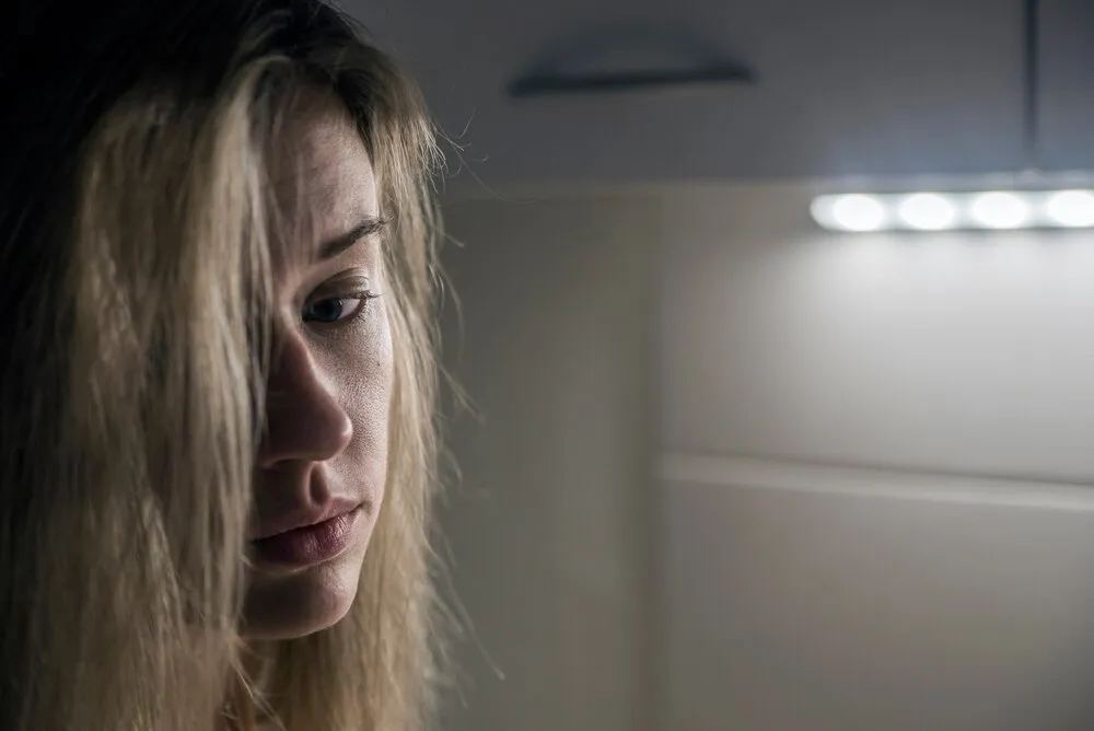 samotna dziewczyna przy oknie myśląca o czymś. melancholijne odbicie dziewczyny w oknie